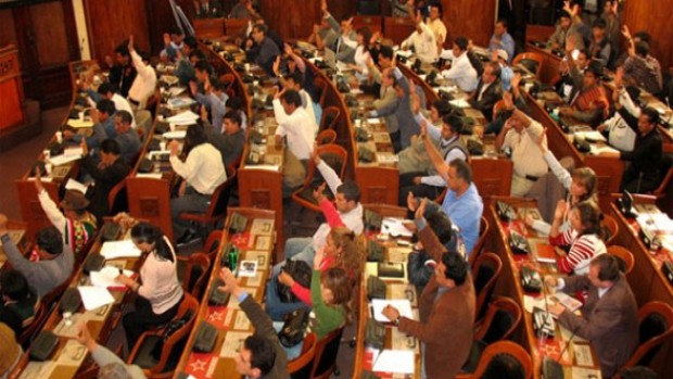 Foto de diputados en sesión parlamentaria levantando la mano