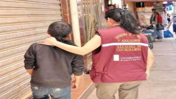 Foto de una funcionaria municipal de la Defensoría de Cochabamba atendiendo a un niño de la calle